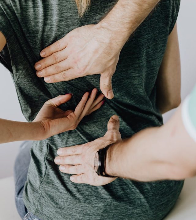 pexels-photo-4506109-4506109-1 A chiropractor examining a patient's back to alleviate pain and discomfort.